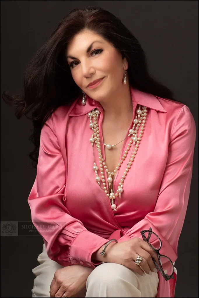 Lifestyle branding portrait of a businesswoman wearing a pink blouse in a modern studio setting.
