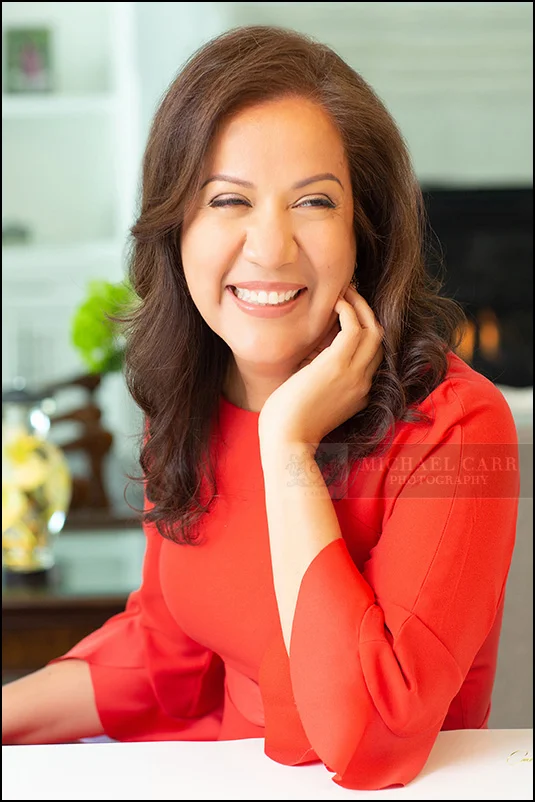 Smiling businesswoman in a red blouse photographed for a professional personal branding session.
