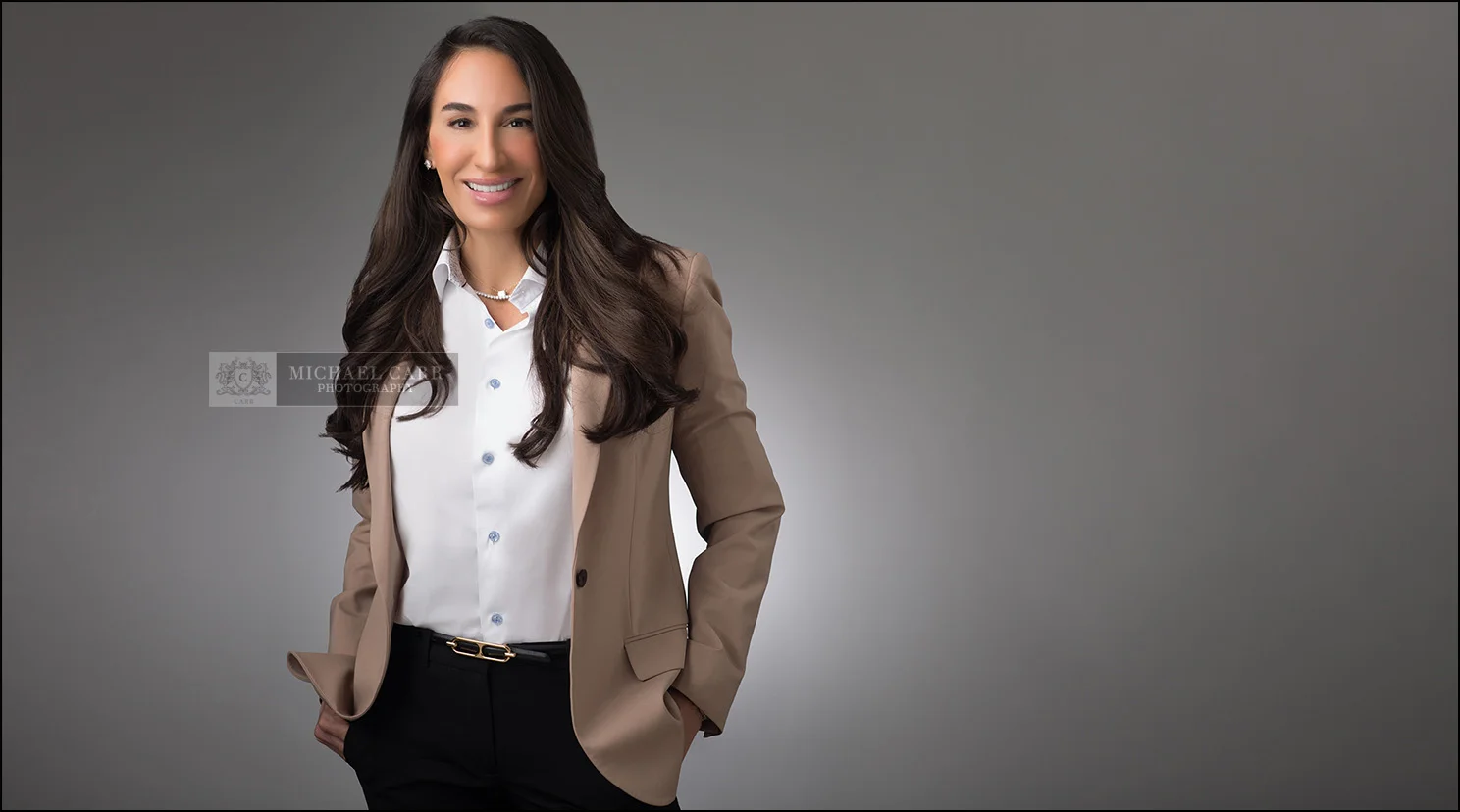 full-length-businesswoman-headshot Full-length portrait of a businesswoman wearing a tan blazer in a modern Houston photography studio.