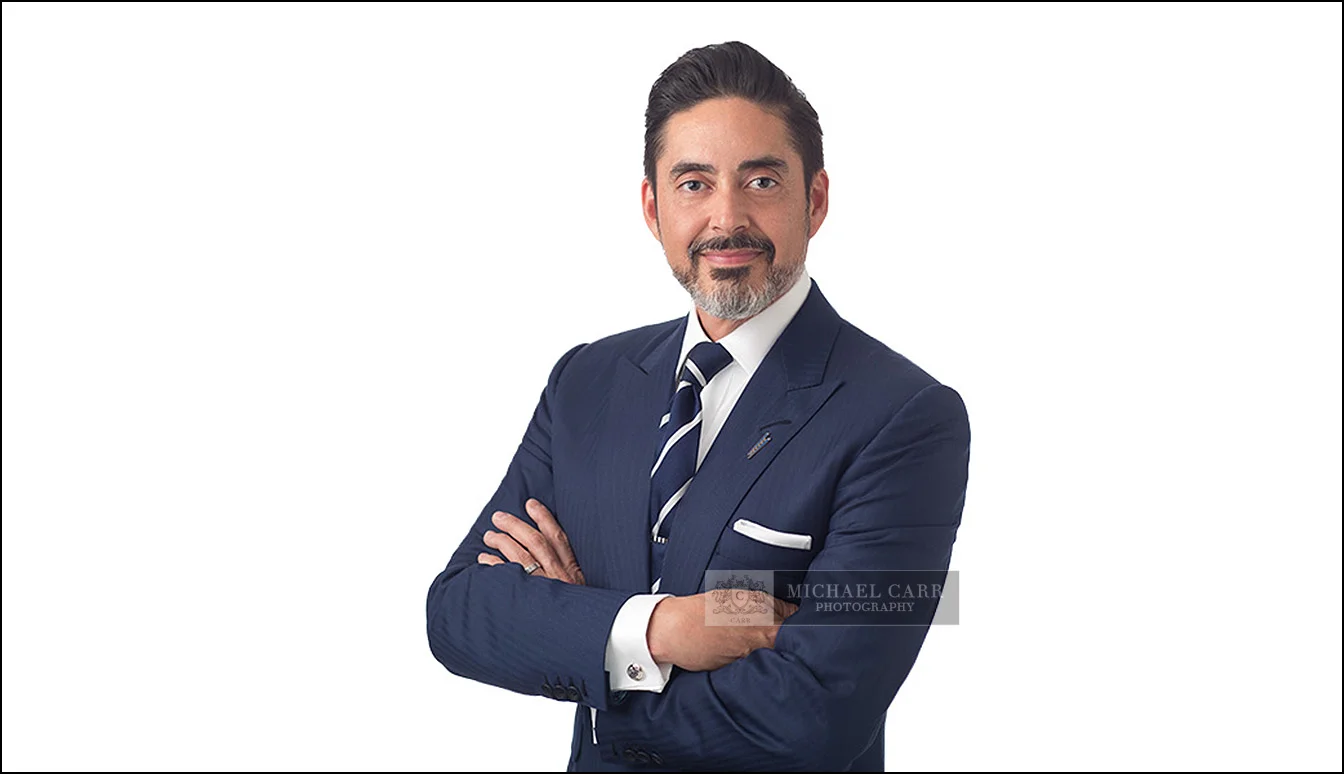 houston-headshot-photographers-businessman-white-background Professional businessman with folded arms photographed against a clean white studio background.