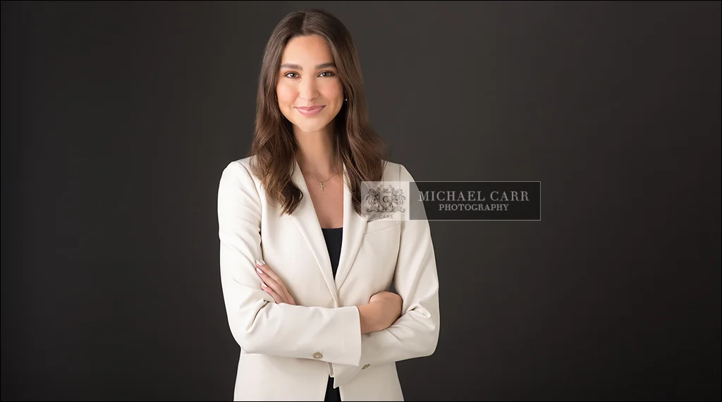 Houston personal branding portrait of a professional woman wearing a white blazer and black turtleneck on a white background.