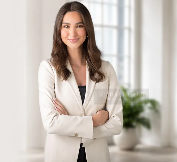 Houston personal branding portrait of a professional woman wearing a white blazer and black turtleneck on a white background.