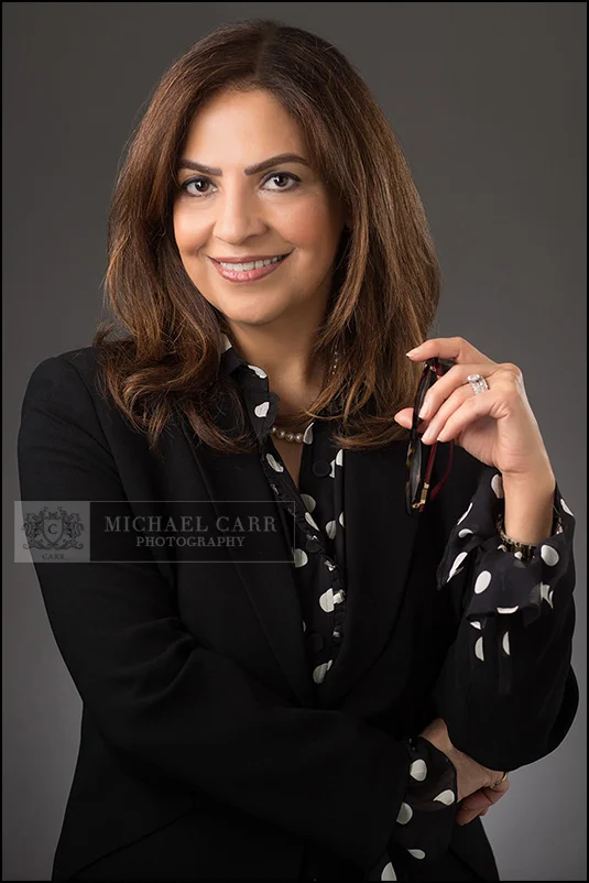 Professional branding portrait of a Houston small business CEO photographed on a gray studio background.